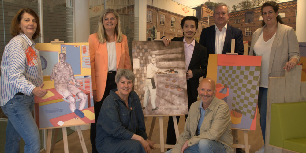 Zeven personen poseren bij kunstwerken geplaatst op drie ezels.