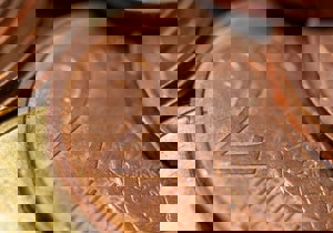 Fotograaf Andrew Dawes (Unsplash) - Close-up van munten, met een koperen 2-cent munt centraal in beeld.