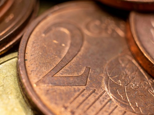 Fotograaf Andrew Dawes (Unsplash) - Close-up van munten, met een koperen 2-cent munt centraal in beeld.