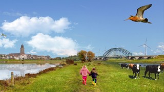 Landschapsbeeld Overijssel – twee kinderen lopen door een groen rivierlandschap met koeien, windmolens, vogels en op de achtergrond de skyline van een stad met brug en kerktoren.