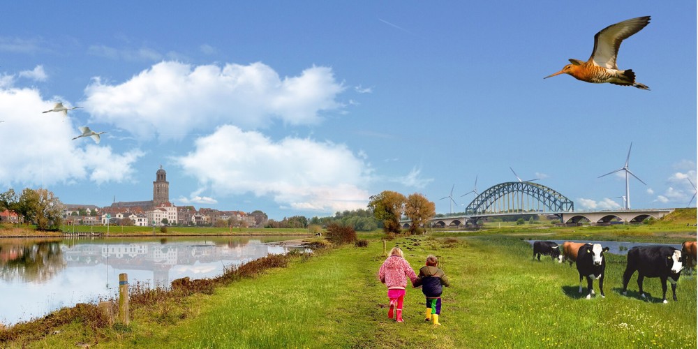 Landschapsbeeld Overijssel – twee kinderen lopen door een groen rivierlandschap met koeien, windmolens, vogels en op de achtergrond de skyline van een stad met brug en kerktoren.
